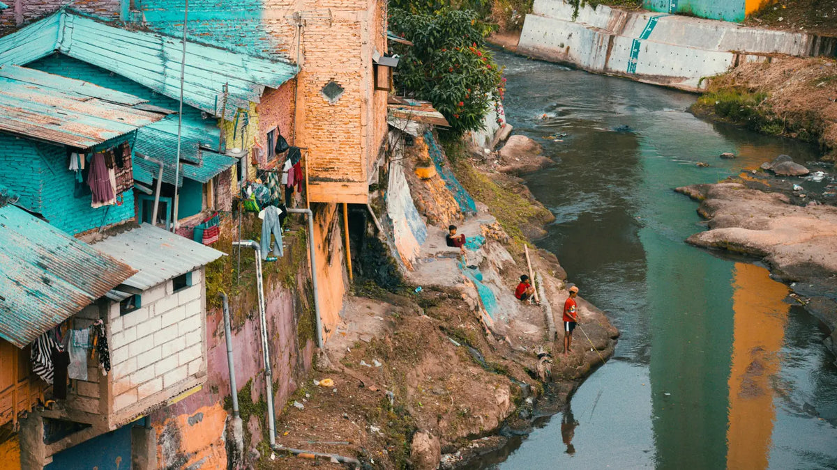 Rivière polluée bordée d’habitations, où se déversent les eaux usées.